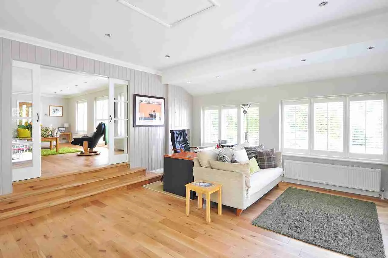 The Hidden Costs of Cheap Flooring You Should Know About 3 Bright open living space with natural hardwood flooring and area rug showing flooring contrast