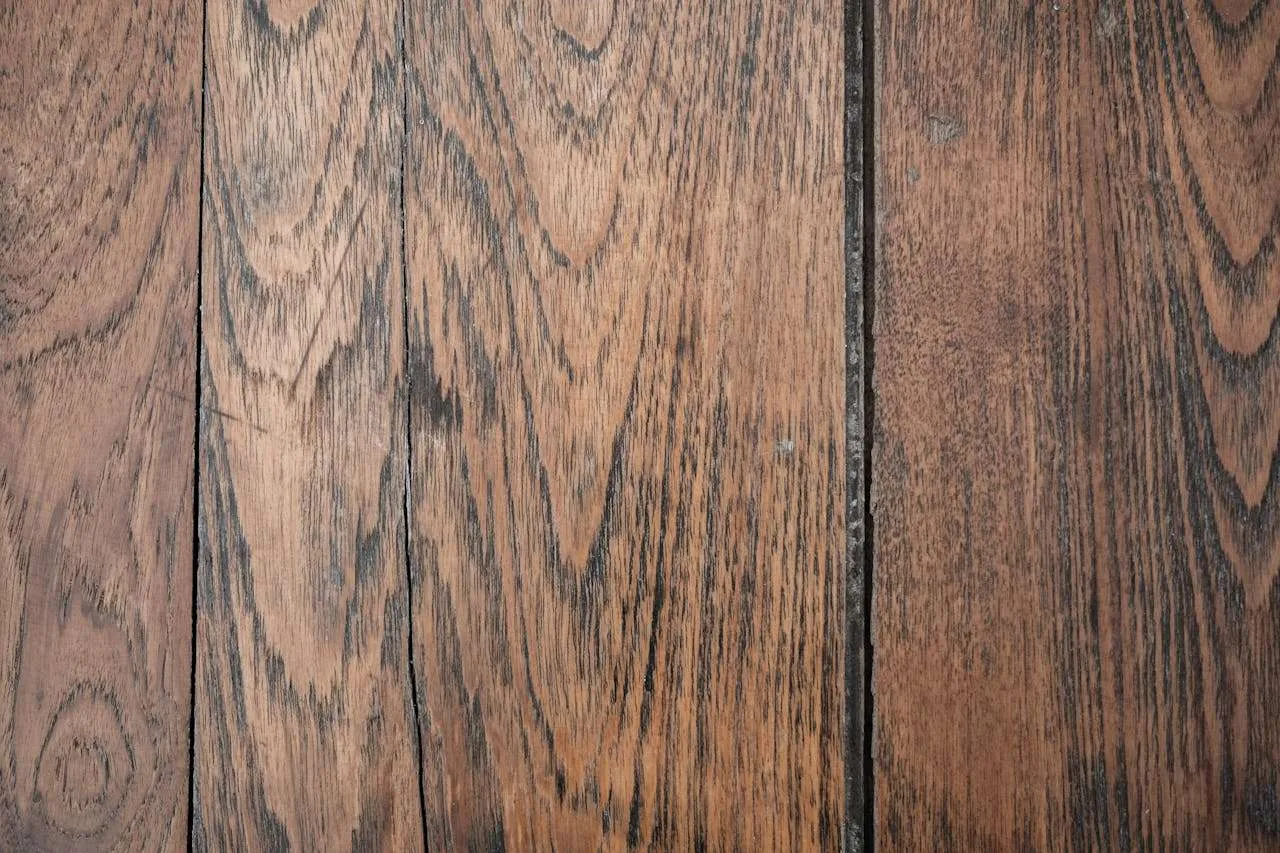 Hardwood vs. Vinyl vs. Laminate: Which Flooring Fits Your Lifestyle? 3 Close-up of rustic hardwood floor planks with natural grain and texture